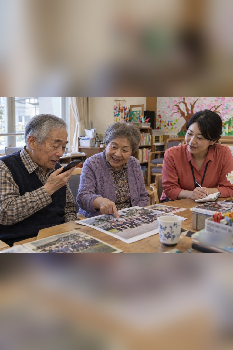 Older adults share photographs while another adult takes notes